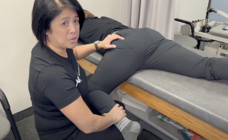 Physical therapist performing leg therapy on patient.
